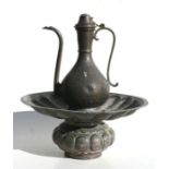 A Middle Eastern copper ewer on bowl, decorated with foliate scrolls and Islamic script, overall