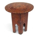 An Islamic or Moorish folding table with inlaid mother of pearl decoration, 43cms wide.
