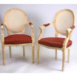 A pair of French distressed painted salon chairs with upholstered seat and caned back (2).