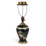 A Cetem ware ceramic oil lamp decorated with sprays of flowers on a black ground, 52cms high