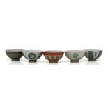 A set of five South East Asian pottery footed bowl each with geometric decoration, in a shelved
