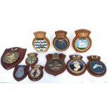 Ten hand painted metal ships crests or tampions mounted on wooden shields including the submarines