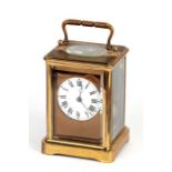 A brass cased carriage clock, the white enamel dial with Roman numerals, the movement striking on