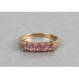 A 9ct gold dress ring set with five pale pink stones, weight 2g, approx UK size 'P'.