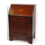 An Edwardian inlaid mahogany bureau of small proportions, the fall-flap enclosing a fitted