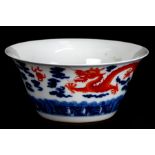 A Chinese blue, white and copper red bowl decorated with dragons chasing a flaming pearl amongst