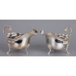 A pair of George III style silver sauce boats with rope twist rims, scroll handles and shell