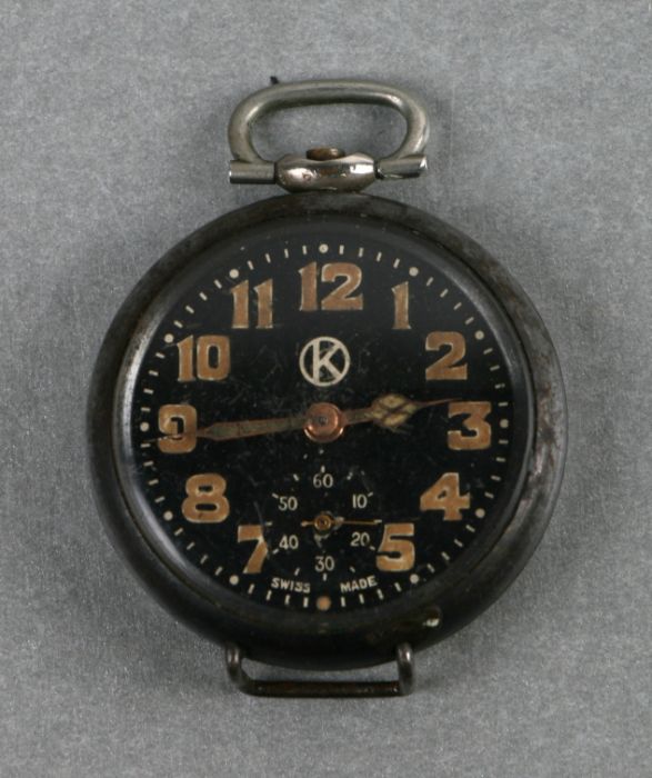 A WWI trench wristwatch adapted from a small pocket watch, the black dial with luminous Arabic