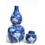 A Chinese blue & white double gourd vase decorated with prunus, 34cms high; together with a