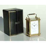 A London Clock Company brass cased carriage time piece, the white enamel dial with Roman numerals,