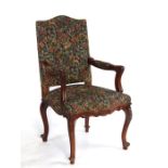 A French walnut elbow chair with upholstered seat and back, on cabriole front supports.Condition