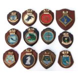 Eighteen hand painted plaster ships crests or tampions mounted on wooden shields including HMS