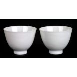 A pair of Chinese white glazed tea bowls with six character blue mark to the underside, 4cms high (