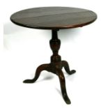 A 19th century oak tilt-top table on turned column and tripod base, 73cms diameter. 70cm high