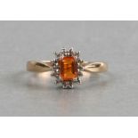 A 9ct gold diamond cluster ring set with a large square central orange stone surrounded by diamonds,