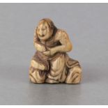 A 19th century Japanese ivory netsuke in the form of a seated man holding a gourd, 3.5cms high.