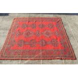 A Turkish rug with repeated medallions on red ground. 286 by 325cm