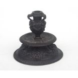 A Renaissance style bronze candlestick in the Venetian manner with grotesque masks and handles,