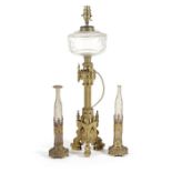 A Victorian gilt bronze gothic revival table lamp with a glass reservoir for oil and decorated