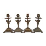 A set of four brass candlesticks with cherub columns and urn sconces, each 20cms high (4).