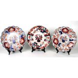 A pair of Imari chargers with wavy rims, decorated with prunus, 30cms diameter; together with