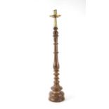 A large turned wooden candlestick with brass sconce (possibly 17th century), 60cms high.