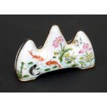 A Chinese Canton enamel brush rest decorated with carp in a pond with lilies and calligraphy, four