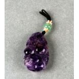 A Chinese carved amethyst hair ornament or pendant in the form of fruit and foliage, 4.5cms high.