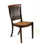 An Arts & Crafts walnut occasional chair with rush seat, on square tapering front supports.