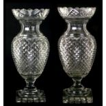An impressive pair of Anglo-Irish Regency cut glass urn vases with fan scalloped rims above cross