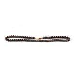 A black pearl necklace with 9ct gold clasp.