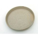 A Chinese celadon glaze shallow dish or brush washer decorated with figures in a procession, 22cms