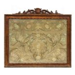 An 18th century silkwork panel decorated with foliate scrolls with central initials, framed &