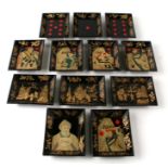 A set of twelve early 19th century rectangular lacquer counter trays decorated with figures, playing