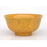 A Chinese yellow glazed porcelain bowl with raised dragon decoration, six character mark to base,