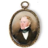 A Regency period oval bust portrait miniature depicting a gentleman, watercolour on ivory, in a gilt