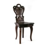 A Black Forest musical chair with profusely carved back and seat.