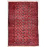 A Persian Balouch rug with repeat design on a red ground, 202 by 115cms (134).