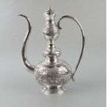 A Chinese silver coloured metal wine ewer decorated in relief with a figure in a landscape and