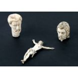 A carved ivory Christ Momento mori, 10cms high; together with two carved busts of men, 7 & 5cms high