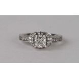 An 18ct white gold diamond ring, approx UK size 'G', the central diamond 0.70ct, with diamond set