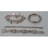A silver charm bracelet; together with two other silver bracelets and a silver bangle, weight 117g.