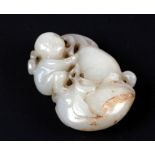A Chinese mutton fat jade carving depicting a young boy climbing on a gourd, with incised signature,