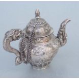 A Tibetan silver teapot with stylised mythical beast spout and dragon handle, 11cms high, weight