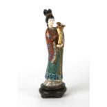 A Chinese cloisonne figure of a robed lady holding a gilded vase of flowers, 31cms high.Condition