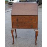 A Queen Anne style oak bureau, the fall-front enclosing a fitted interior, above two drawers, on