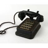 A vintage Bakelite and steel hotel telephone with push-button keys numbered one to twenty.