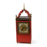 A red painted metal cased mantle clock with silvered chapter ring and Roman numerals, overall