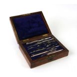 A cased set of Army & Navy drawing instruments in a figured walnut case, 21cms wide.