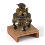A Japanese earthquake detector in the form of a turtle sat on a rock, on a lacquer stand, fitted